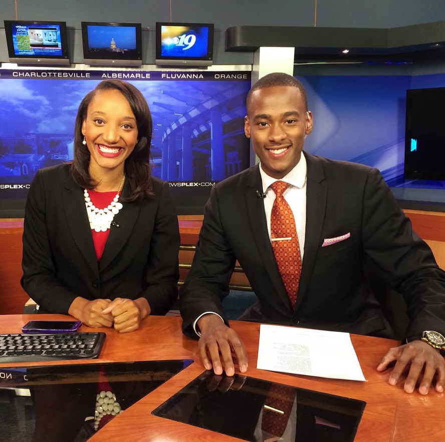 Stephon Dingle and his colleague Loren smile together at the Charlottesville anchor desk in 2014.