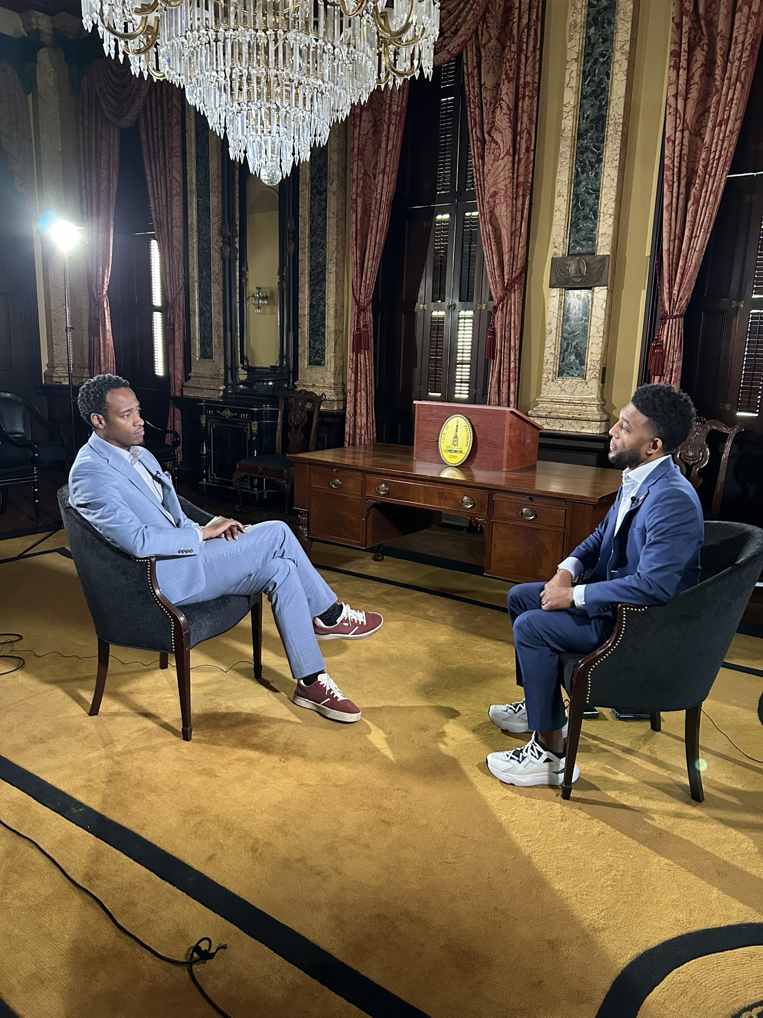 Stephon Dingle interviewing Baltimore Mayor Brandon Scott at City Hall.