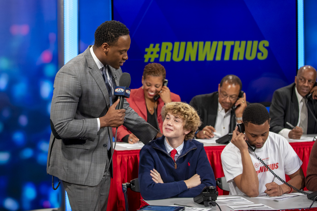 Stephon Dingle mentors a young participant during a live broadcast.
