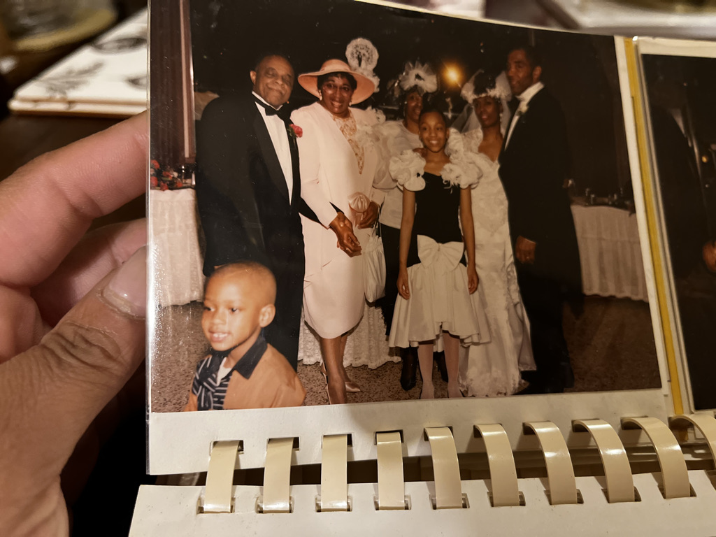 A family album photograph with a young Stephon Dingle visible in the lower-left corner.