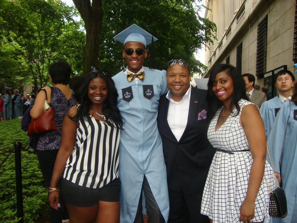 Stephon Dingle in graduation regalia with his sister Jasmine, mentor Steven King and a family friend.