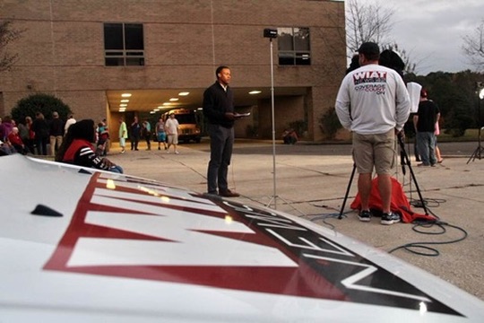 A young Stephon Dingle preparing a live field report for WIAT outside a school.