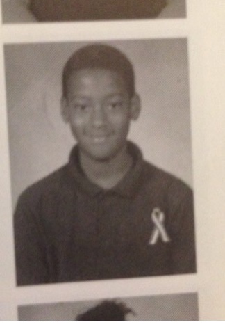 A young Stephon Dingle in a Roland Park school portrait wearing a ribbon on his shirt.